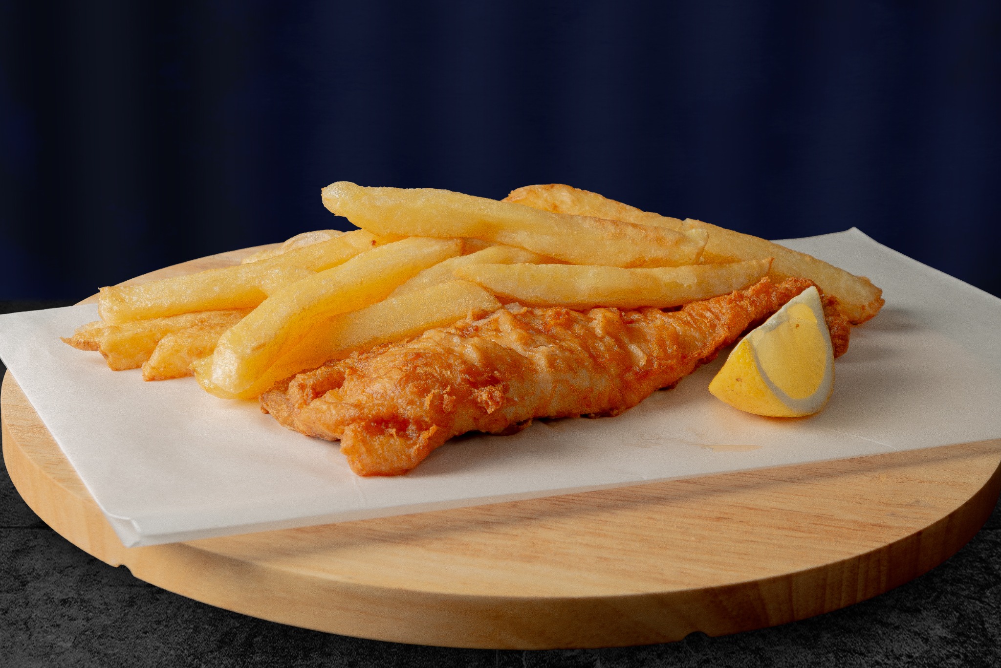Golden battered fish served with chips and lemon at Fishermans Choice